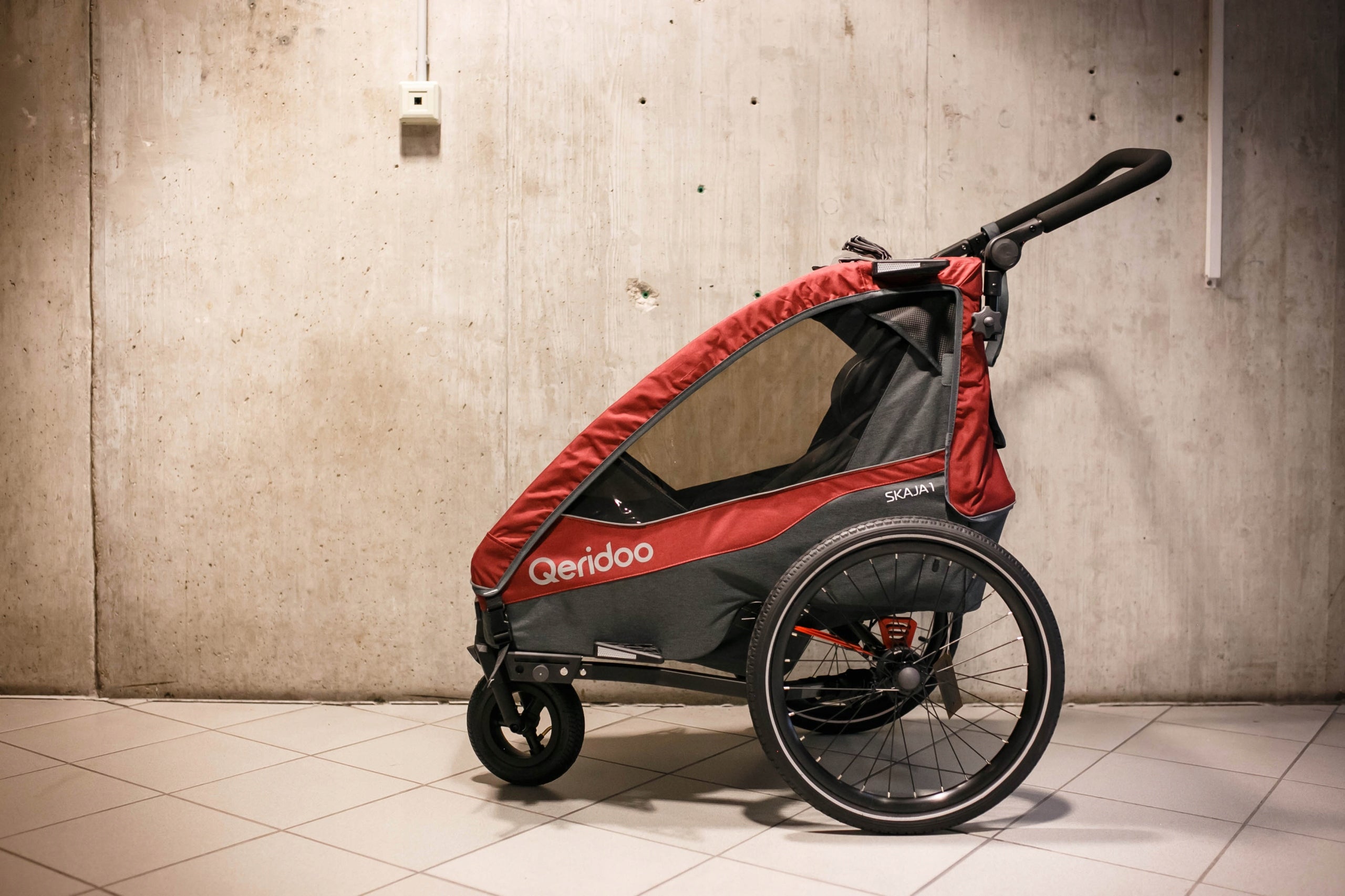 Qeridoo Skaja 1 single bicycle trailer for children Additional features shock absorption safety flag rain cover jogger function brake pockets stroller front wheel included axle-mounted mosquito net hi-vis reflectors sun visors lighting securing straps 5-point harness pumped wheels cargo space adjustable handles foldable trailer design waterproof bicycle trailer hook walking set covered